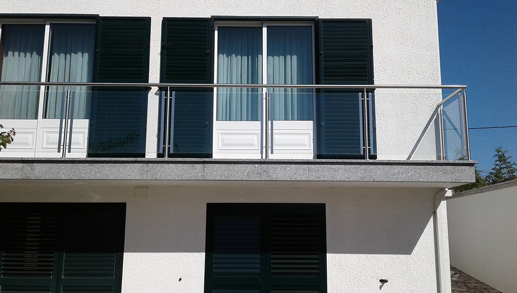 Varanda com grade de metal e vidro
