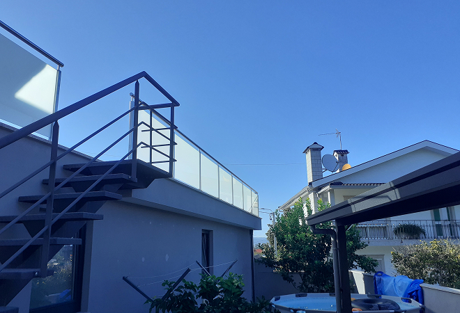 Escada de metal com grade de ferro e vidro perto de cobertura metalica